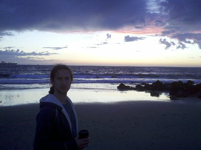 Cody drinking coffee at dusk on El Segundo beach