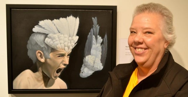 Woman smiling in front of "Death of a Budgie-Sattva"