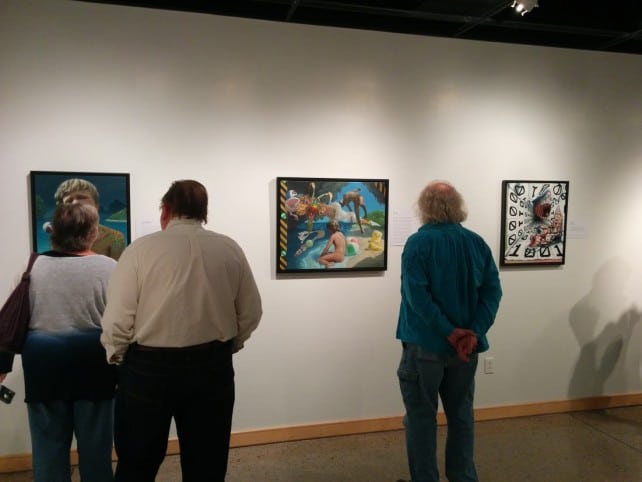 Attendees viewing Cody's paintings.